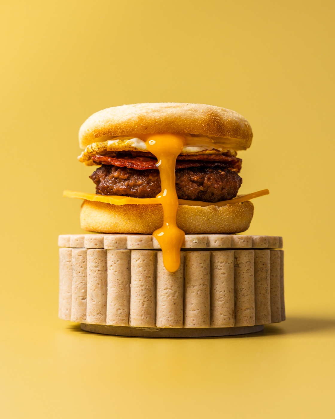 Breakfast muffin with a runny egg on a stone stand